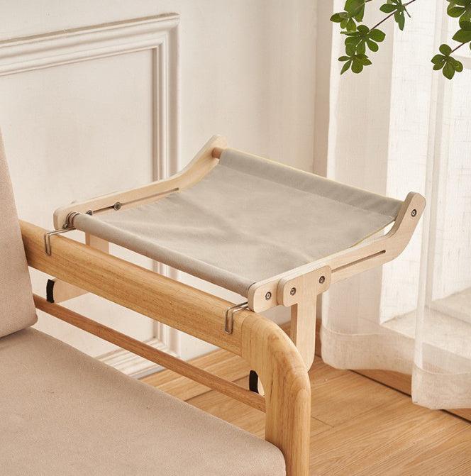 Minimalist cat hanging bed with a neutral gray fabric and wooden frame, designed for secure attachment to furniture or windows.